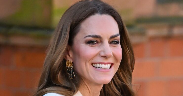 Princess Kate smiling wearing gold earrings