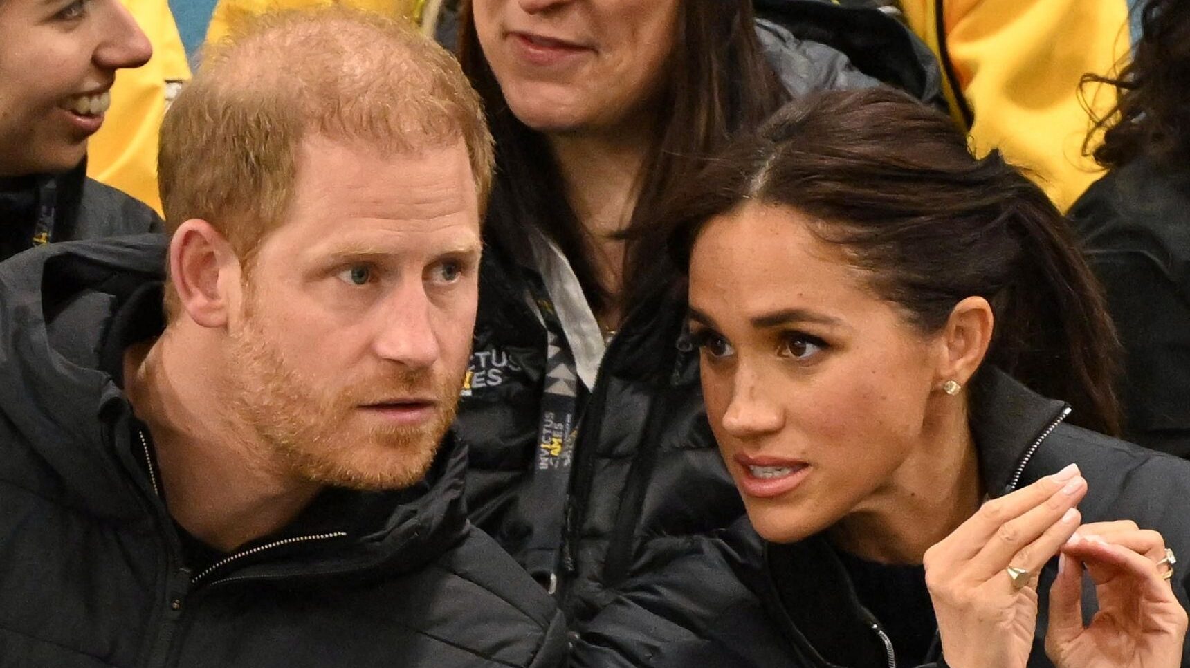 Prince Harry and Meghan frowning and talking