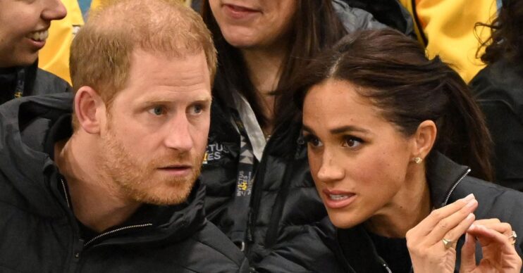 Prince Harry and Meghan frowning and talking