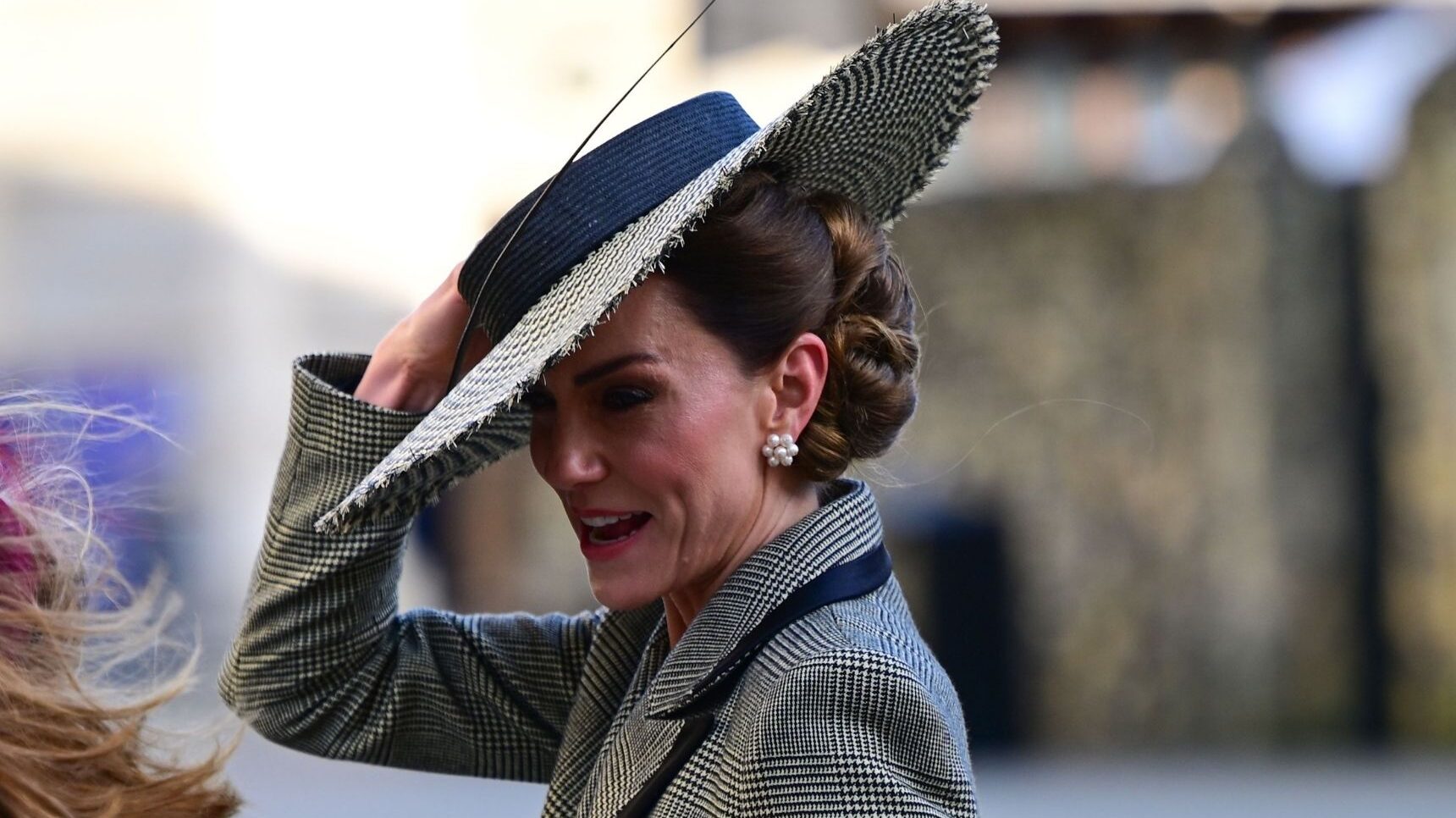 Kate Middleton holding onto her hat