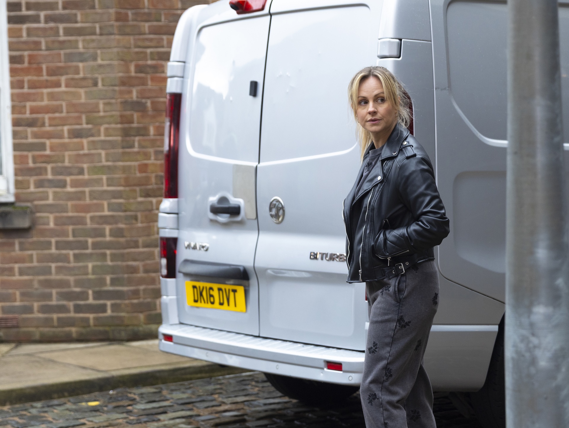 Sarah sneaking behind van 