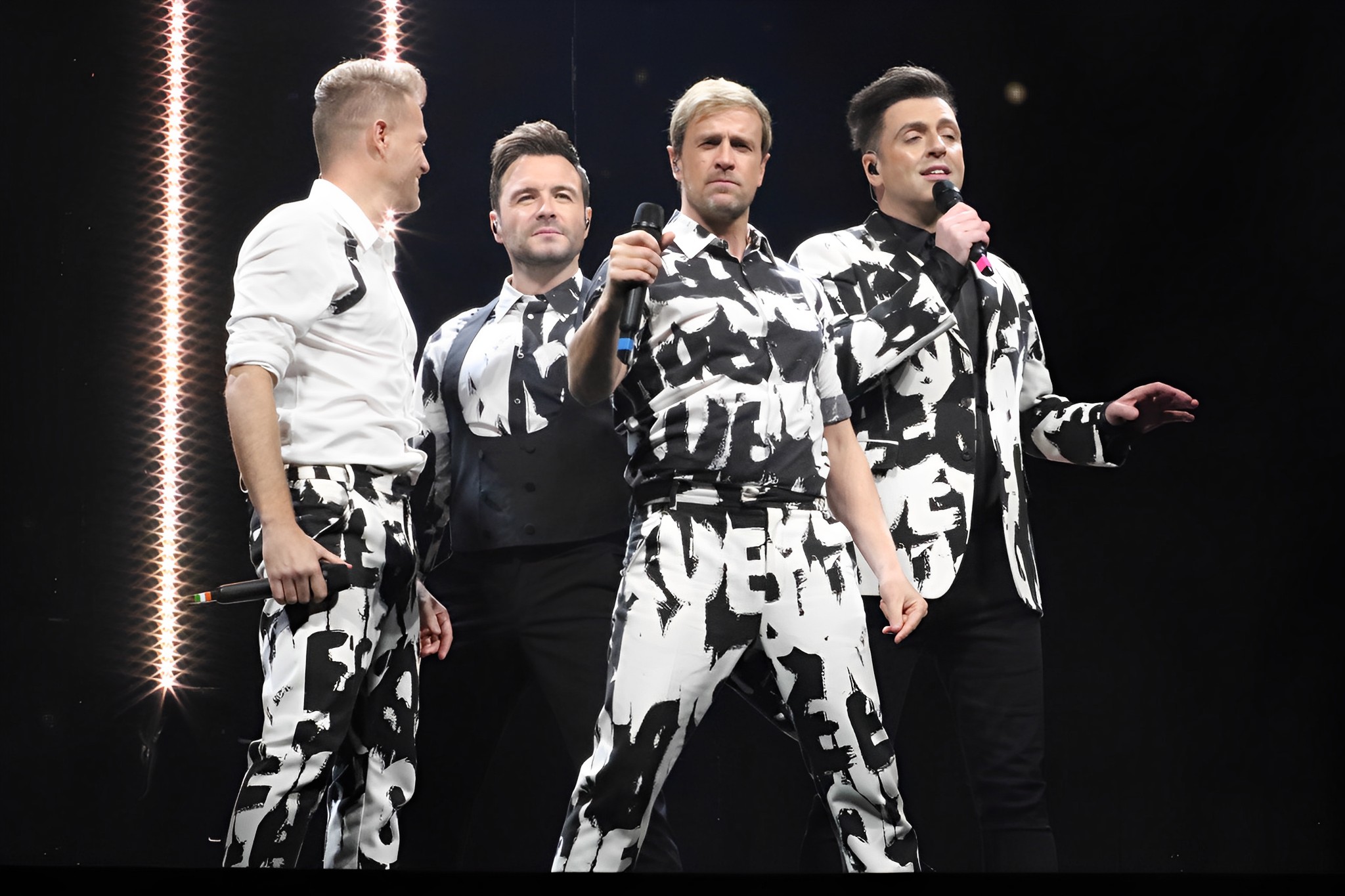 Westlife in black and white outfits on stage
