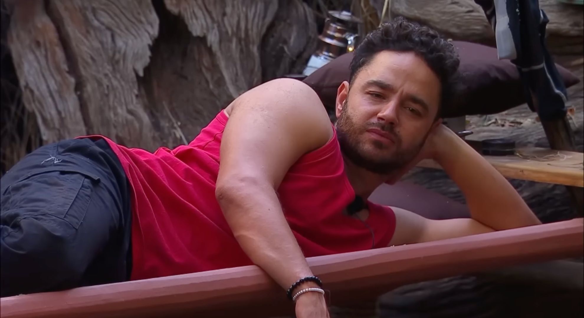Adam Thomas lying on a camp bed on I'm A Celebrity 