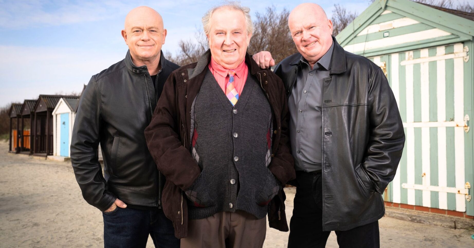 Grant, Nigel and Phil all standing in front of beach huts together