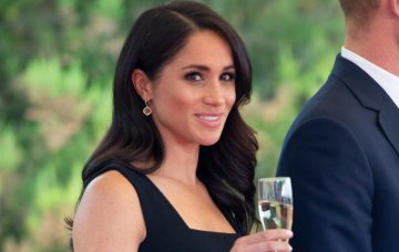 Meghan smiles with champagne glass