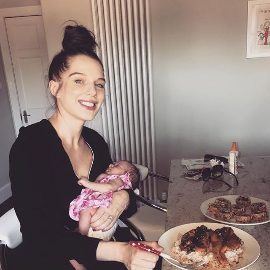 Helen Flanagan eats dinner while holding baby Delilah