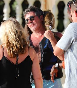Simon Cowell pets a monkey on the beach in Barbados. The couple went for a jet ski ride with son Eric as they continued their sunsoaked vacation in the Caribbean.