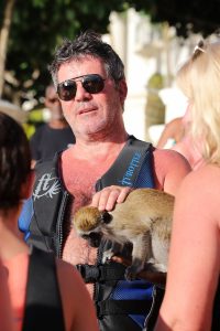 Simon Cowell pets a monkey on the beach in Barbados. The couple went for a jet ski ride with son Eric as they continued their sunsoaked vacation in the Caribbean.