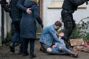 Shona staggers from the building covered in blood and sinks to the ground (Credit: ITV)