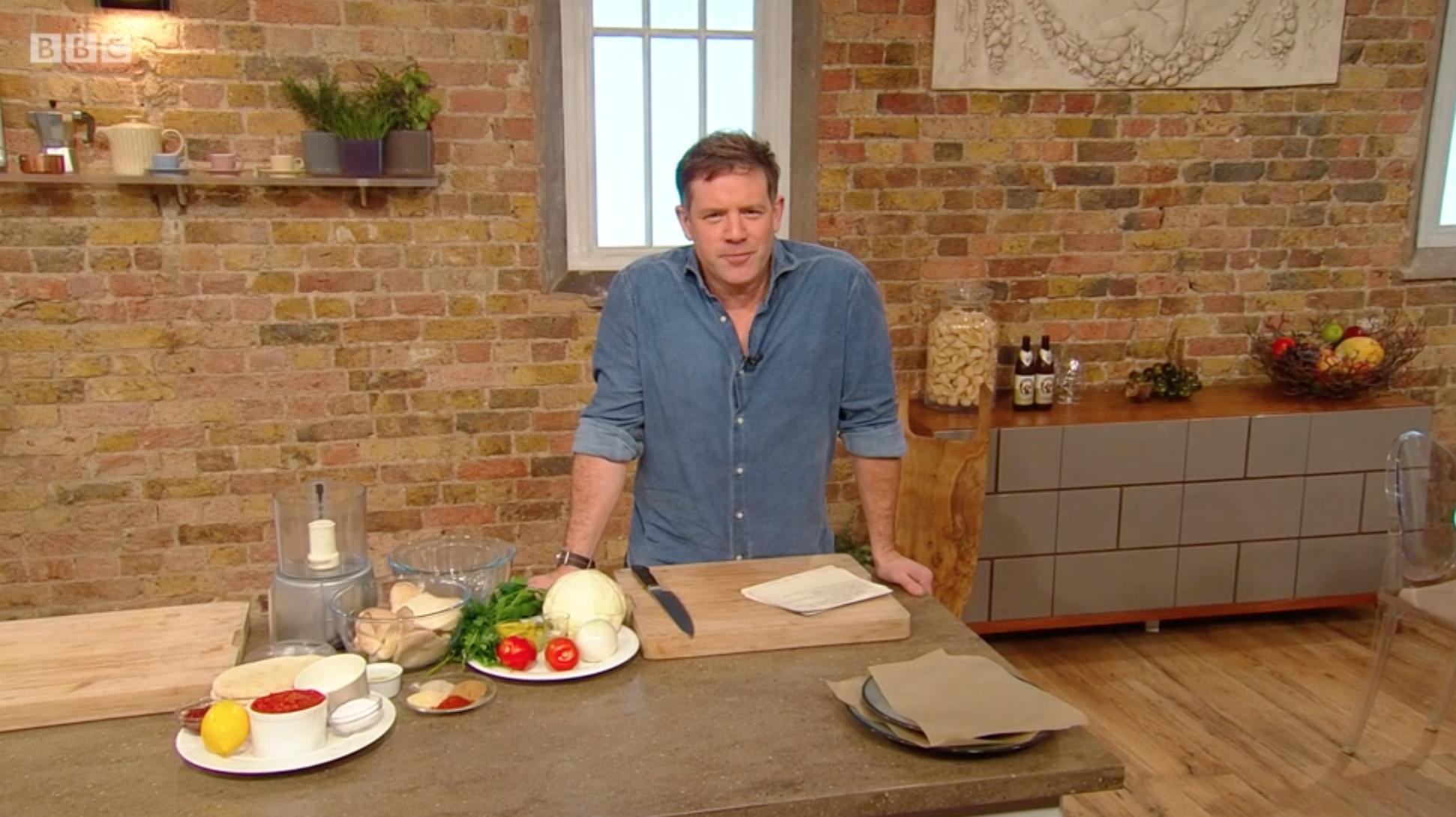 Matt Tebbutt smiling behind his table on Saturday Kitchen
