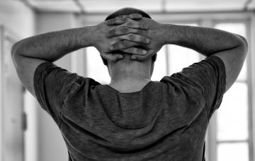 Black and white guy hands behind head