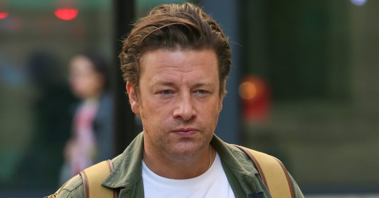 Jamie Oliver avoids the camera as he walks down the street