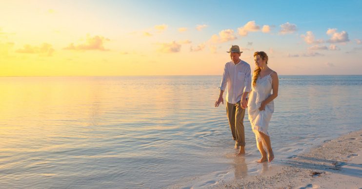 Couple walking on a beach. Coronavirus: UK Foreign Office warns Brits not to travel 'indefinitely'