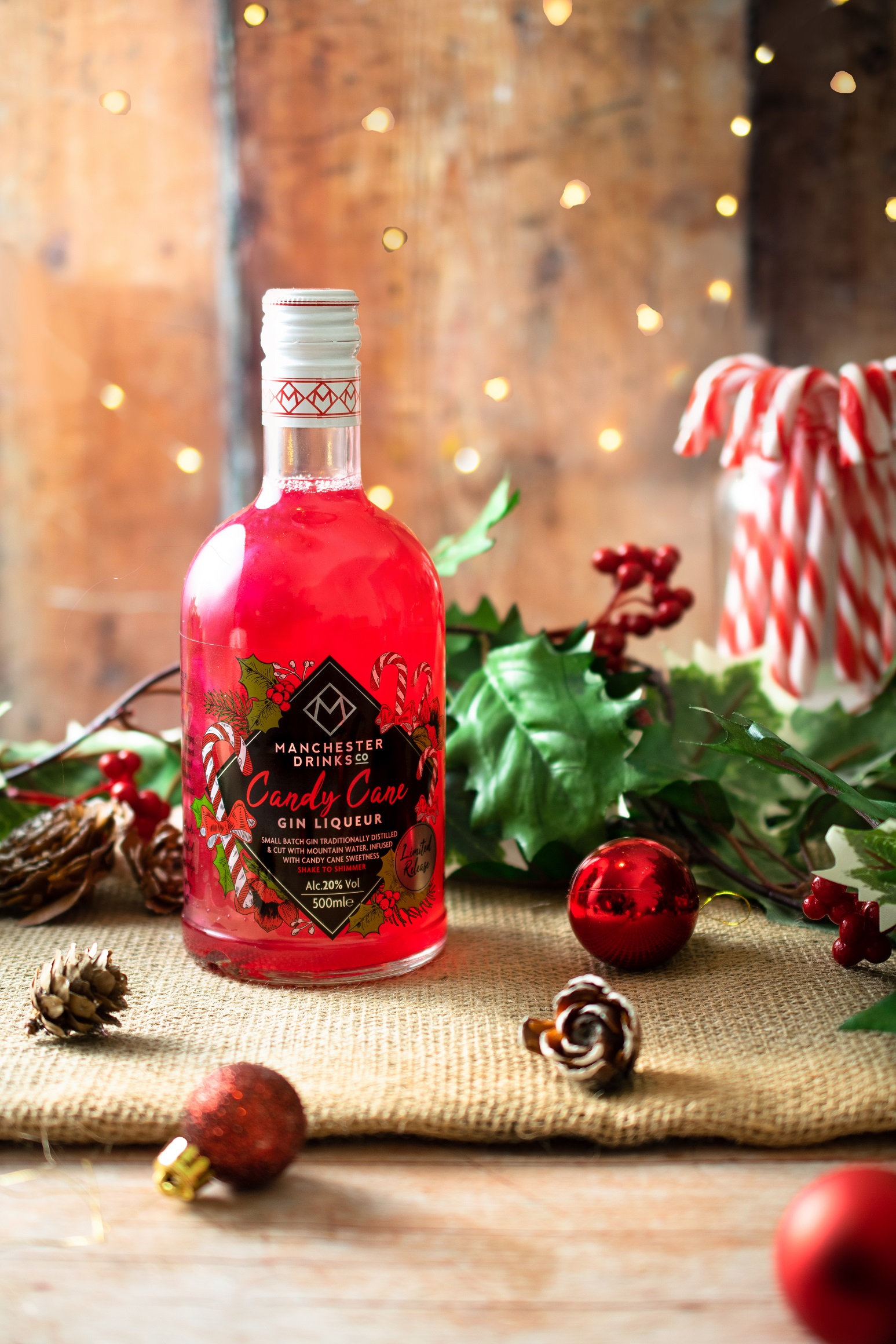 bottle of candy cane gin with pine cones and candy canes around it