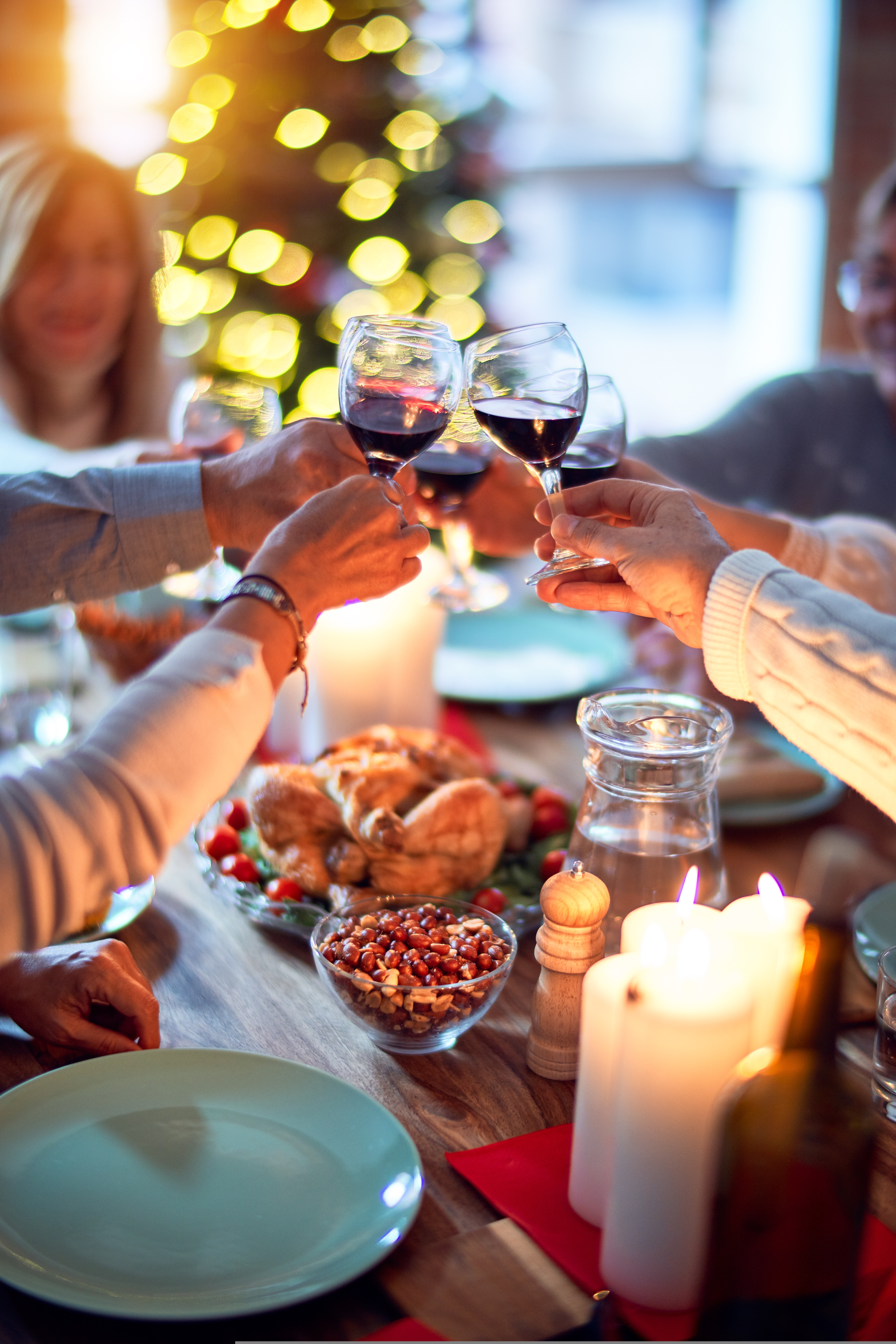 People sitting at a Christmas dinner table with wine