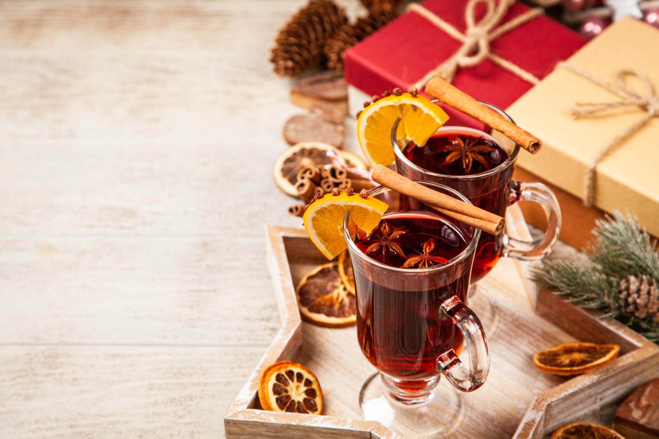 two glasses of mulled wine next to Christmas presents
