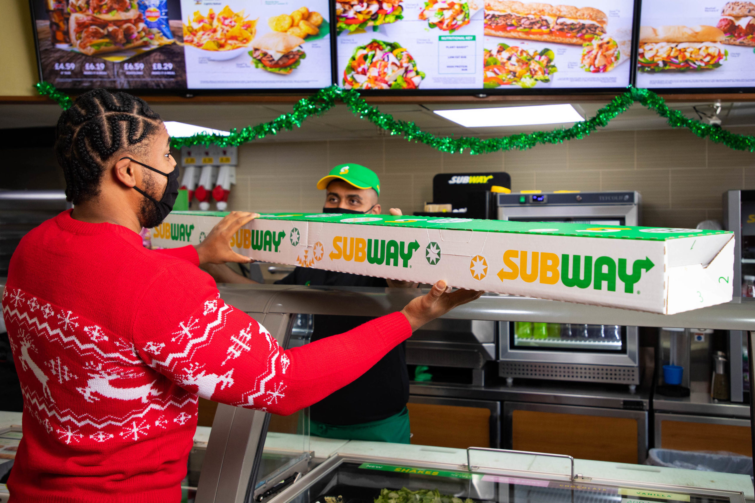 man carrying subway giant pigs in blanket sub