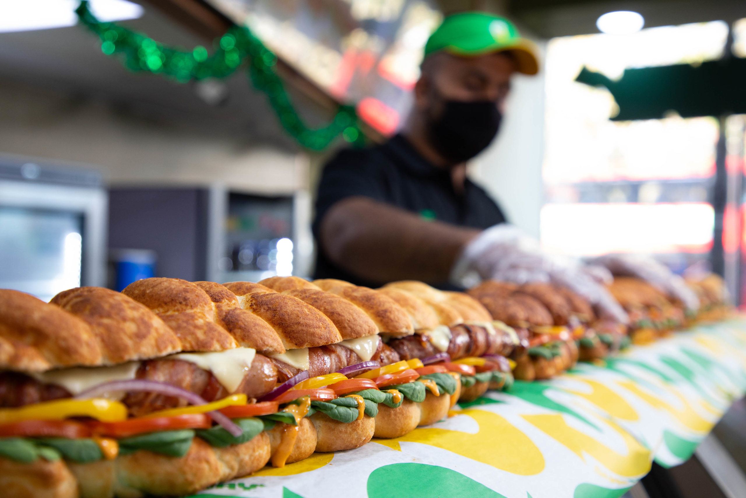 man making subway giant pigs in blanket sub