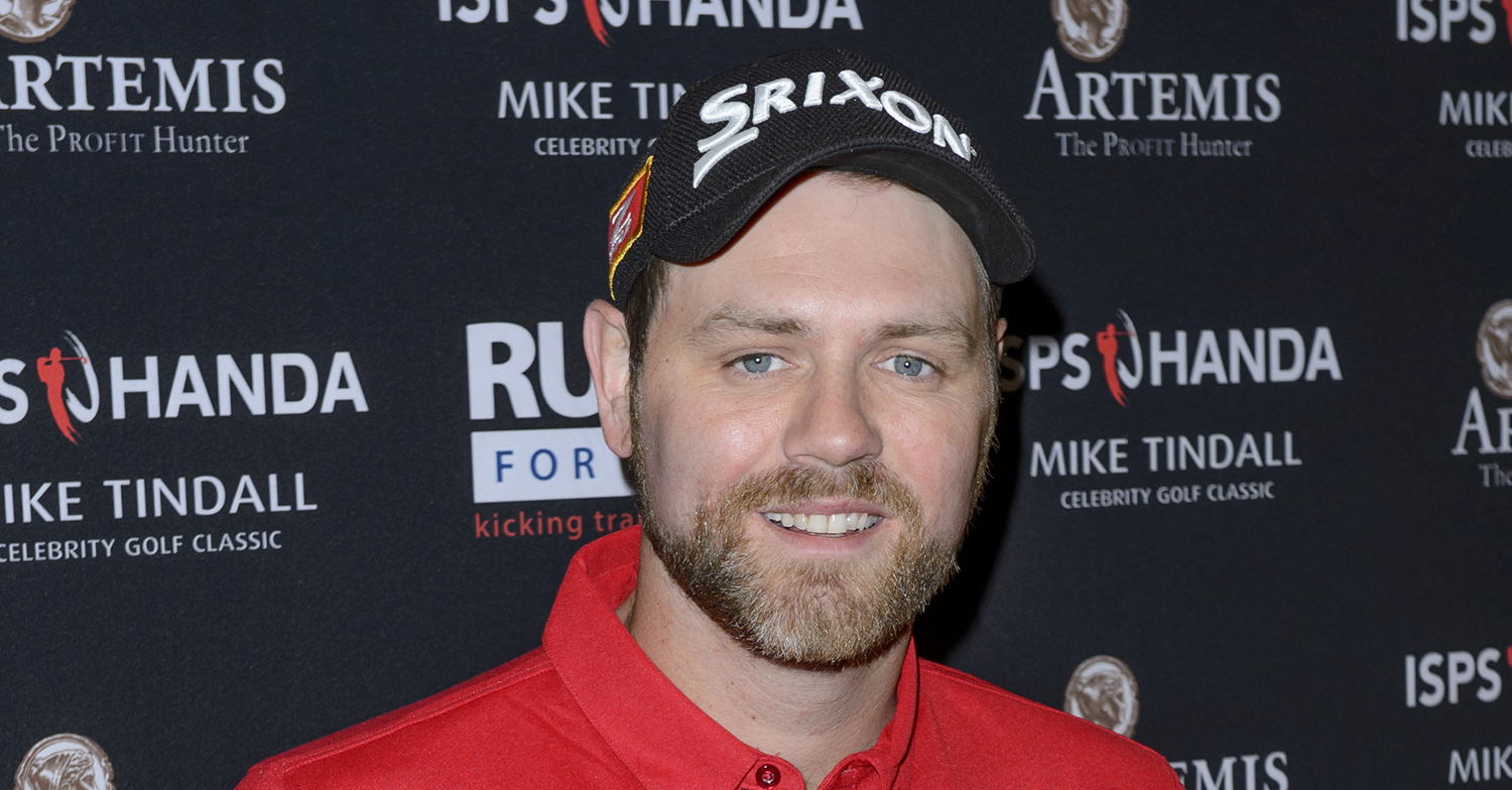 Brian McFadden posing and smiling wearing a cap