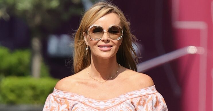 Amanda Holden walking in a summery outfit and sunglasses