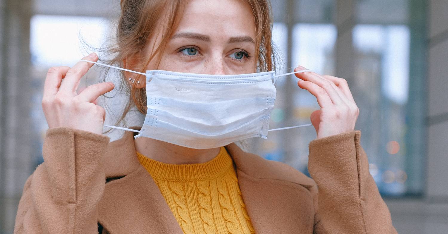 A woman puts on her mask