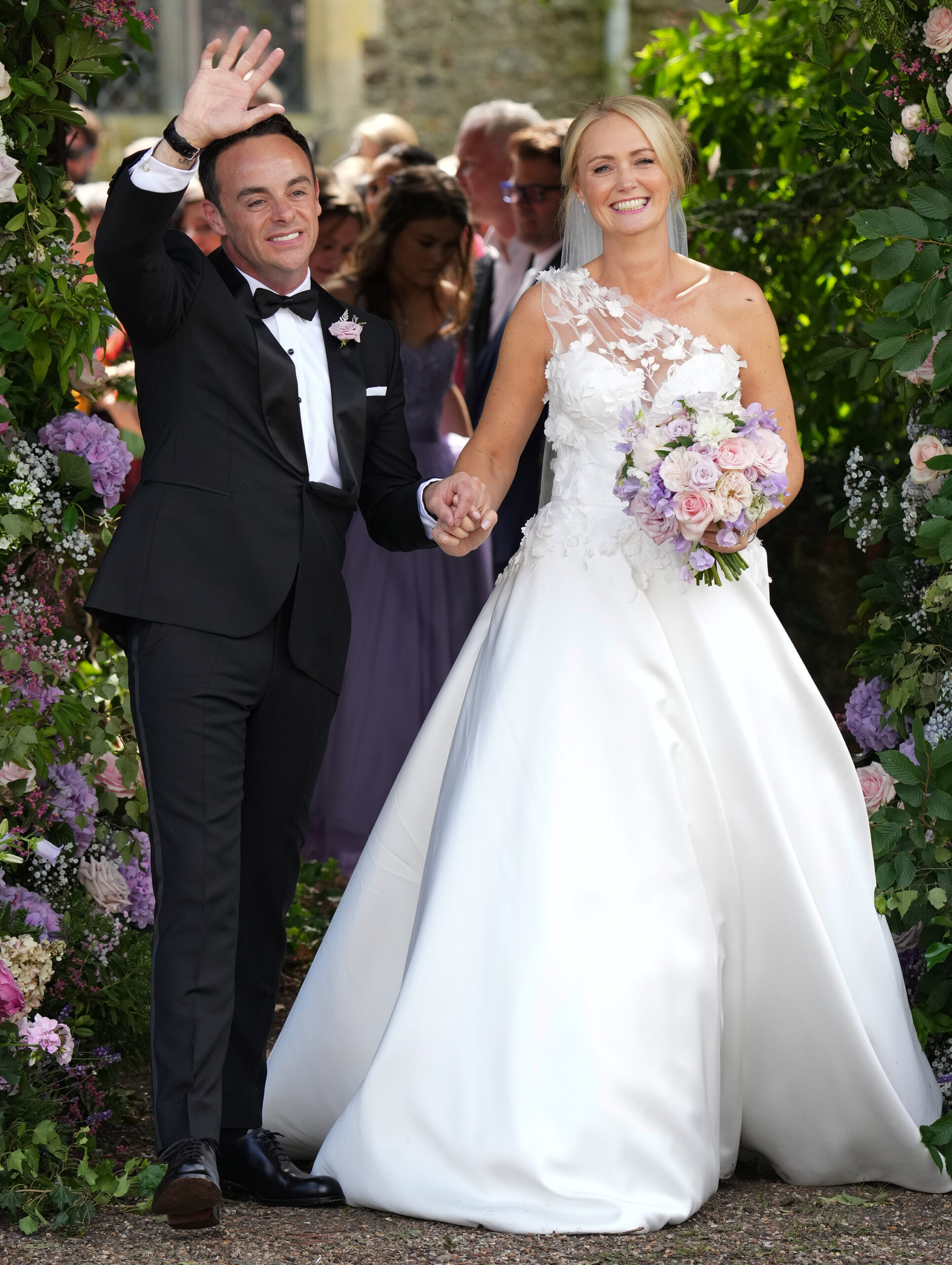 Ant McPartlin and Anne-Marie Corbett hold hands and wave and smile after getting married 