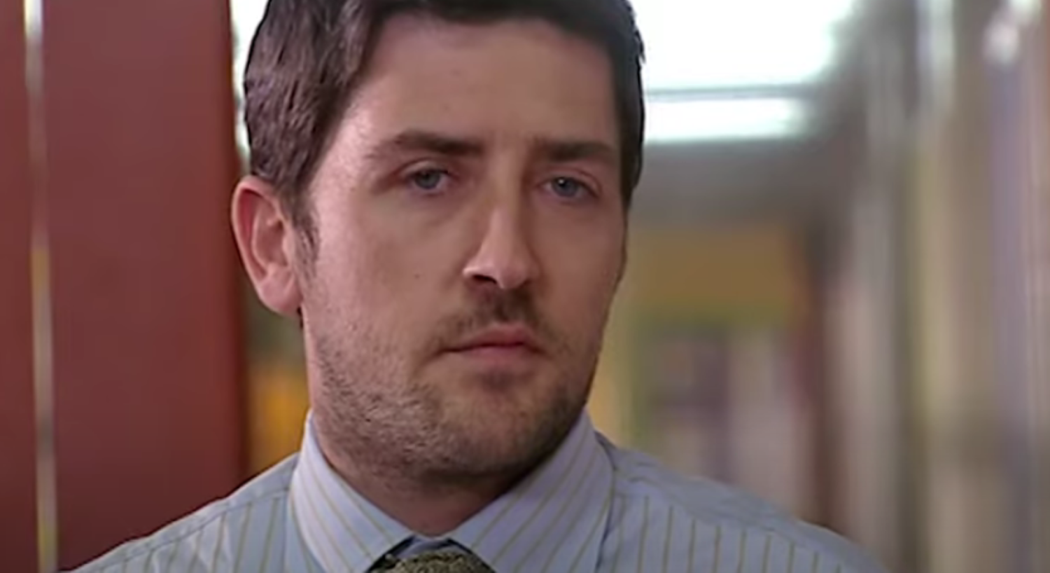Tom Clarkson standing in the school hallway in Waterloo Road