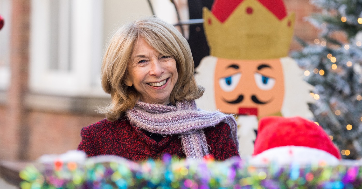 Gail Platt joins her neighbours for a festive sing song on the cobbles this Christmas (Credit: ITV)