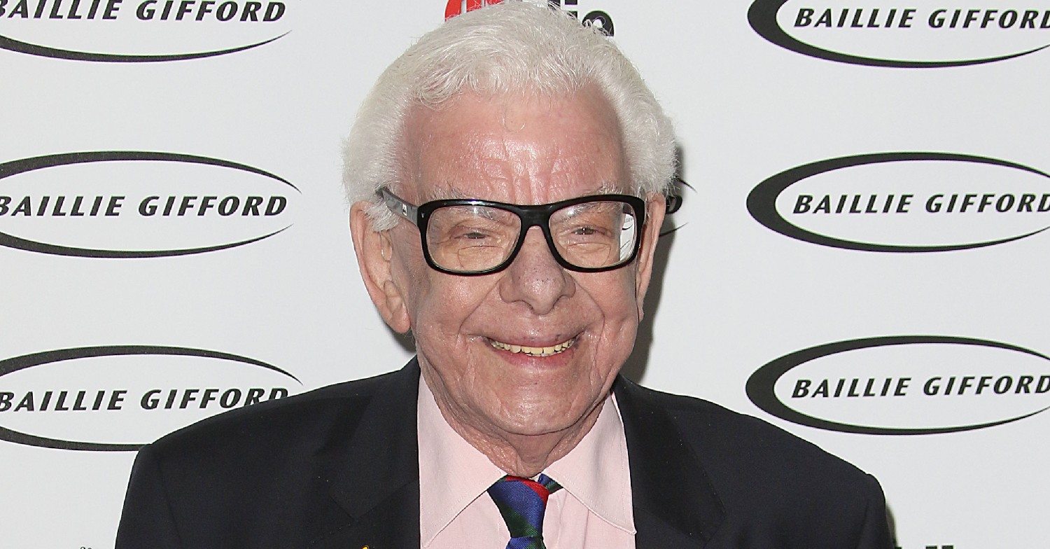 Barry Cryer smiles on the red carpet wearing glasses
