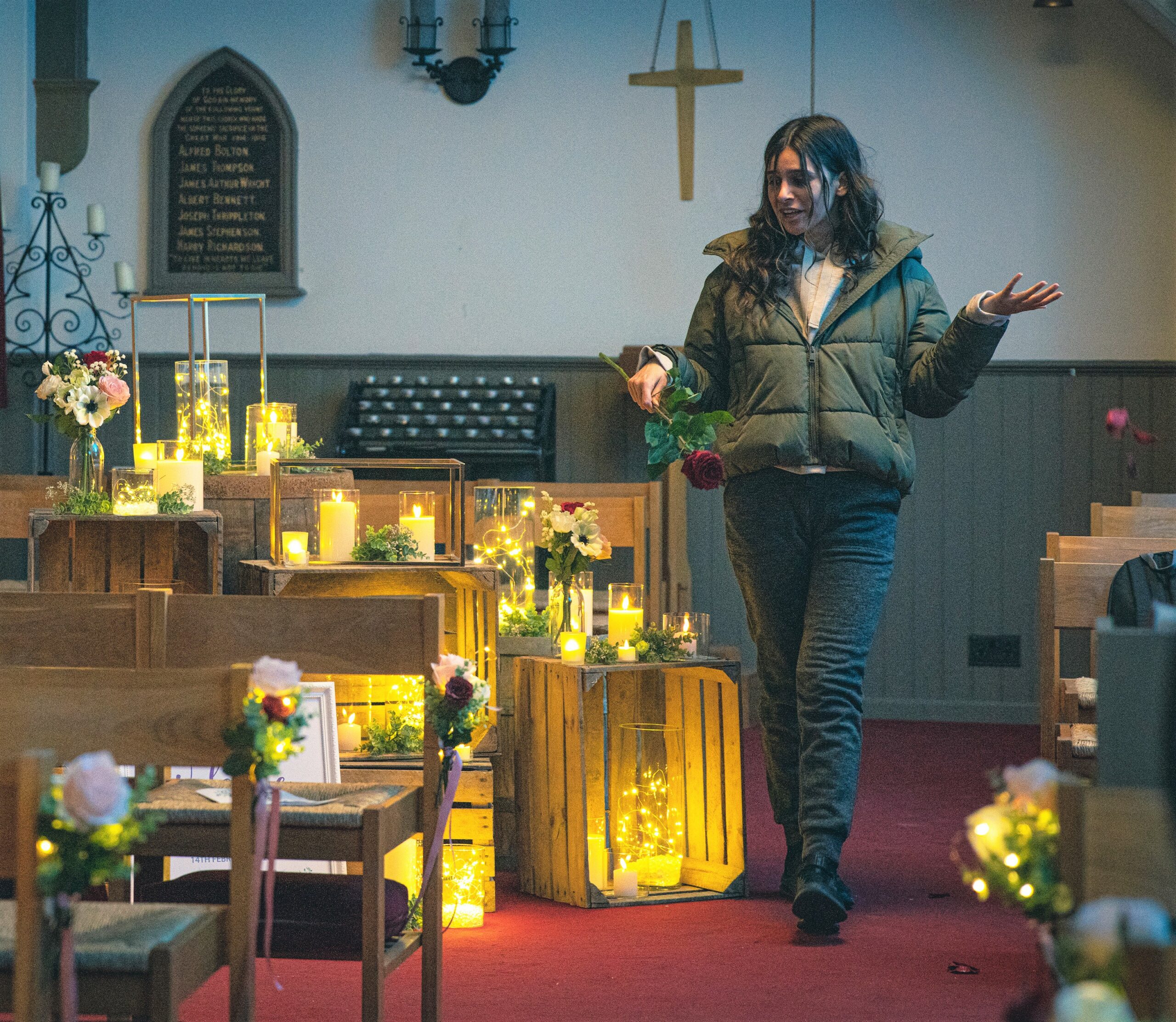 Emmerdale Meena in the candlelit church with a rose clearly talking to herself madly