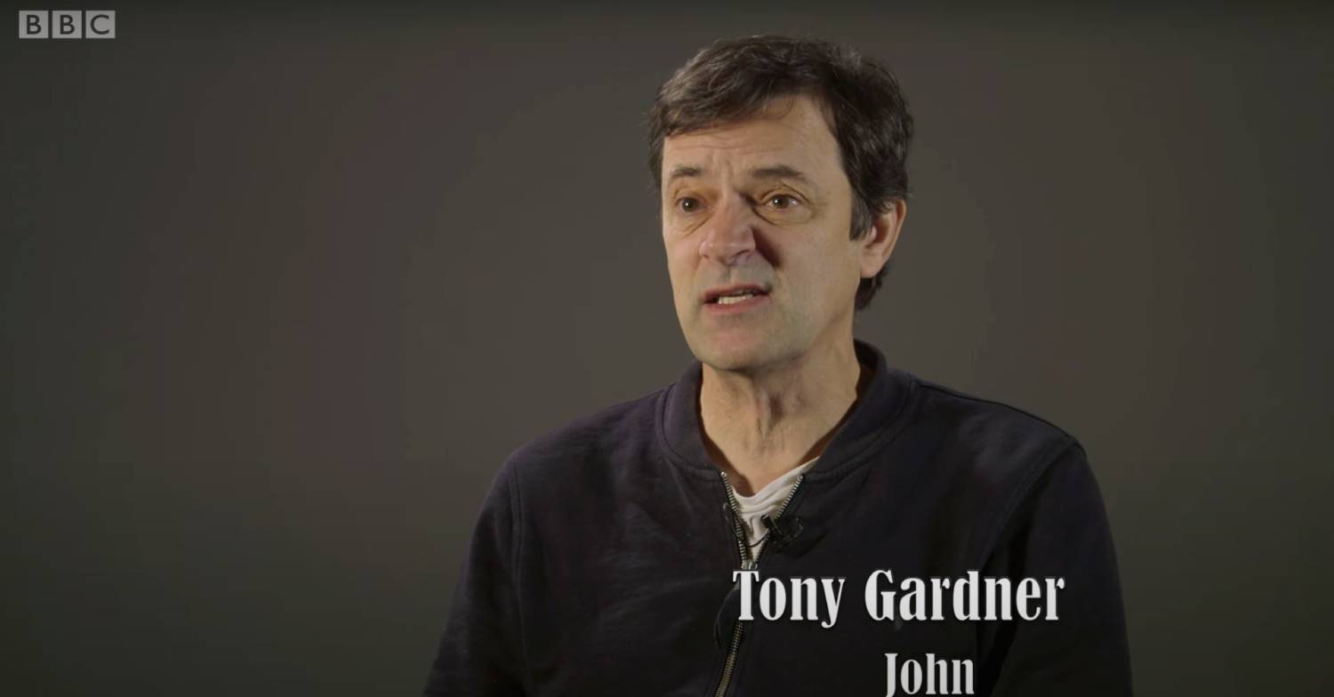 Tony Gardiner chatting against a grey background