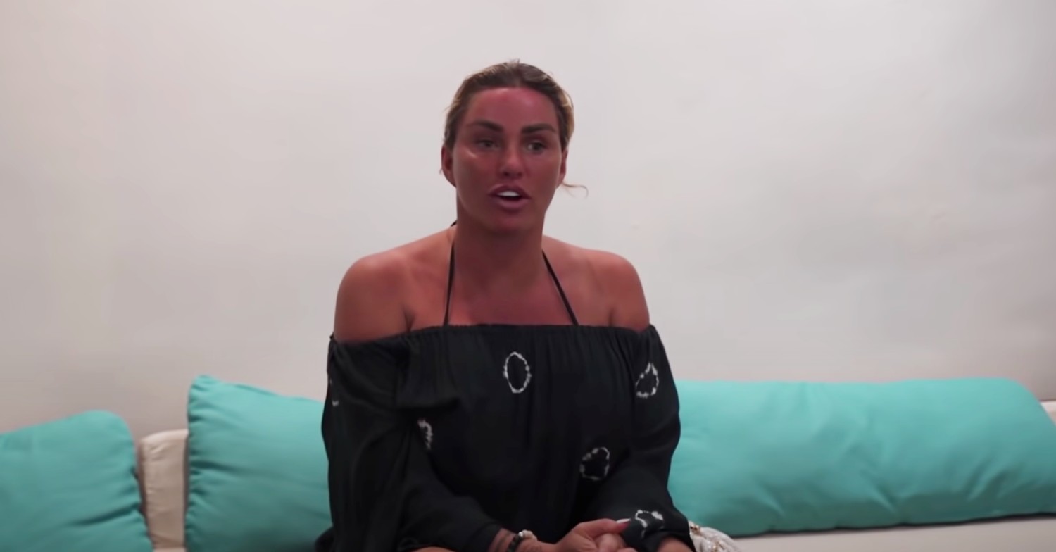 Katie Price sitting down, speaking to camera while on holiday