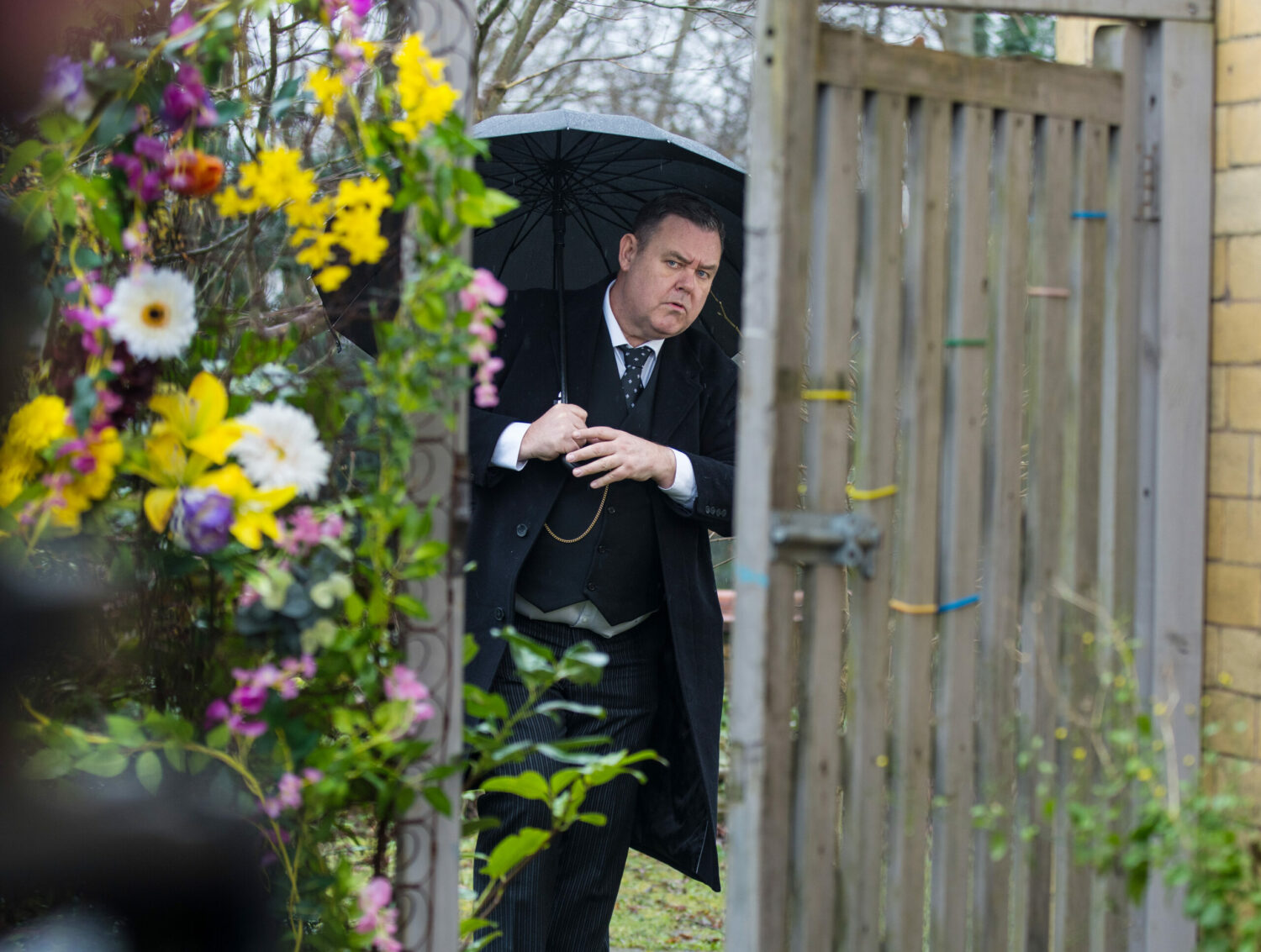 Coronation Street George with umbrella spots Eileen in the garden