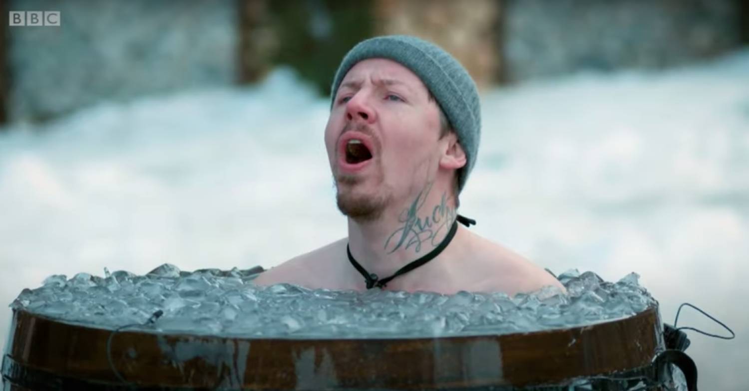 Professor Green sitting in a barrel of ice
