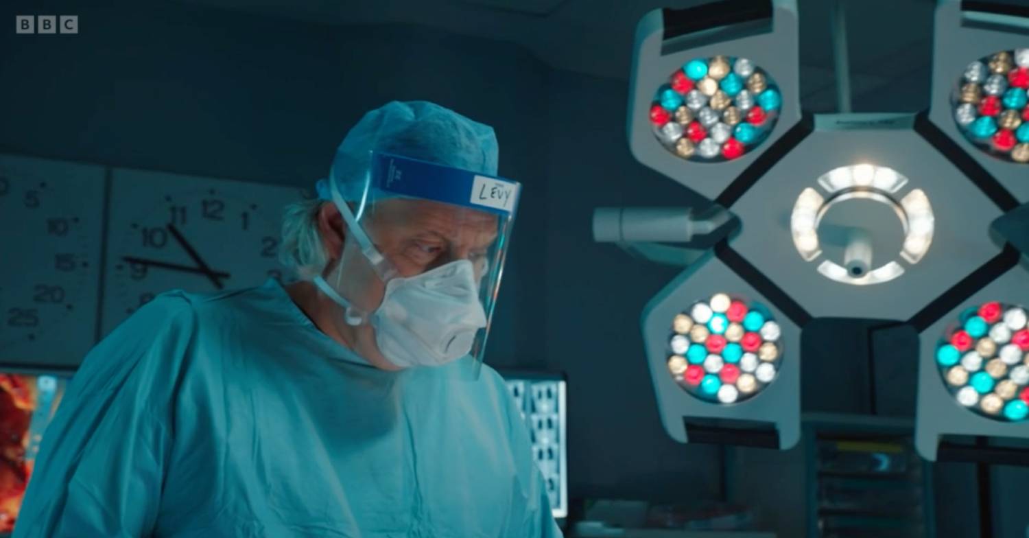 A surgeon in the operation theatre on Holby City wearing scrubs