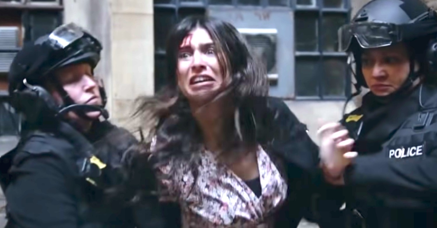 Meena grimacing in Emmerdale as she's captured by two armed police (Credit: ITV)