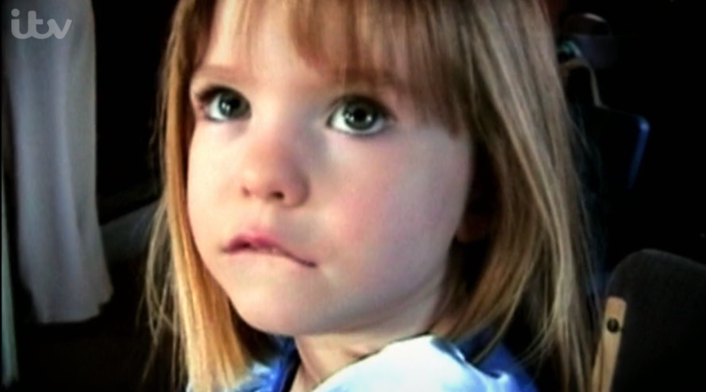 Madeleine McCann wearing a blue top looking up