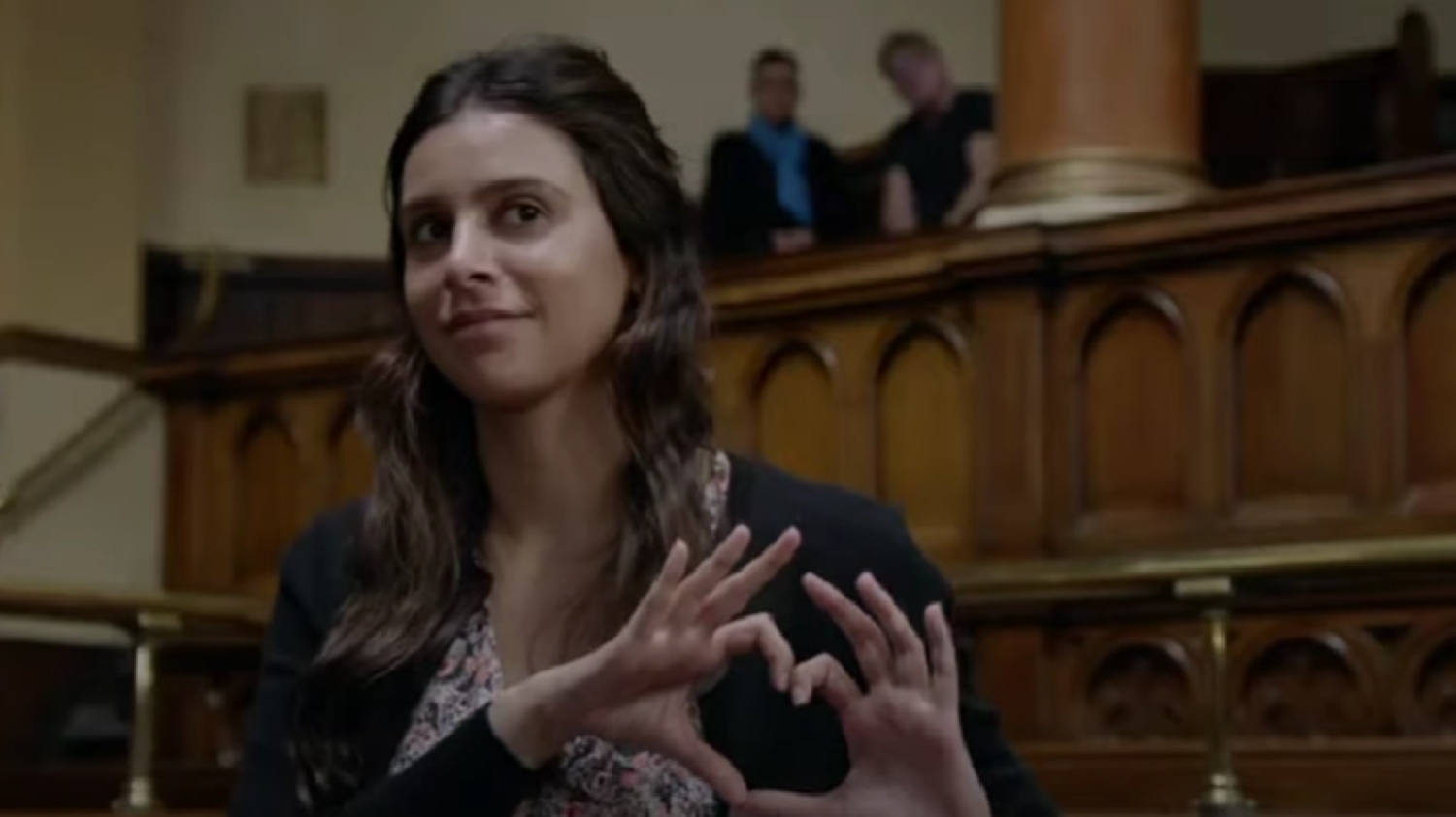 Emmerdale's Meena is in court, making a heart symbol with her hands