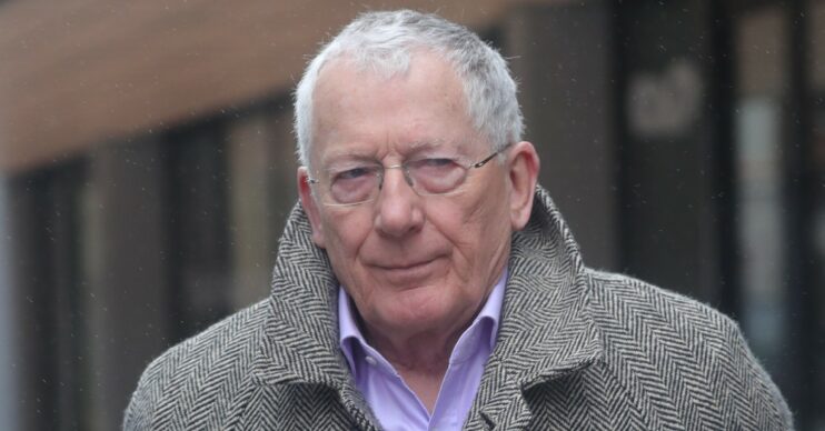Nick Hewer walking with a stern expression