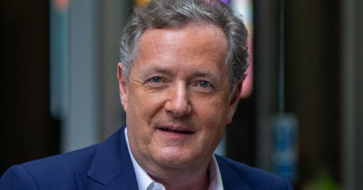 Piers Morgan looks at cameras in navy suit at TV studios