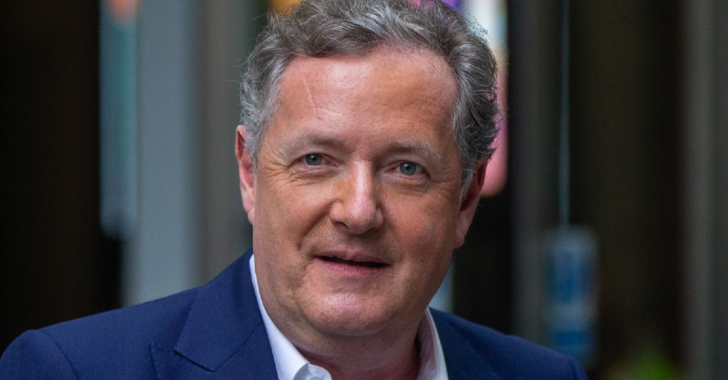 Piers Morgan looks at cameras in navy suit at TV studios
