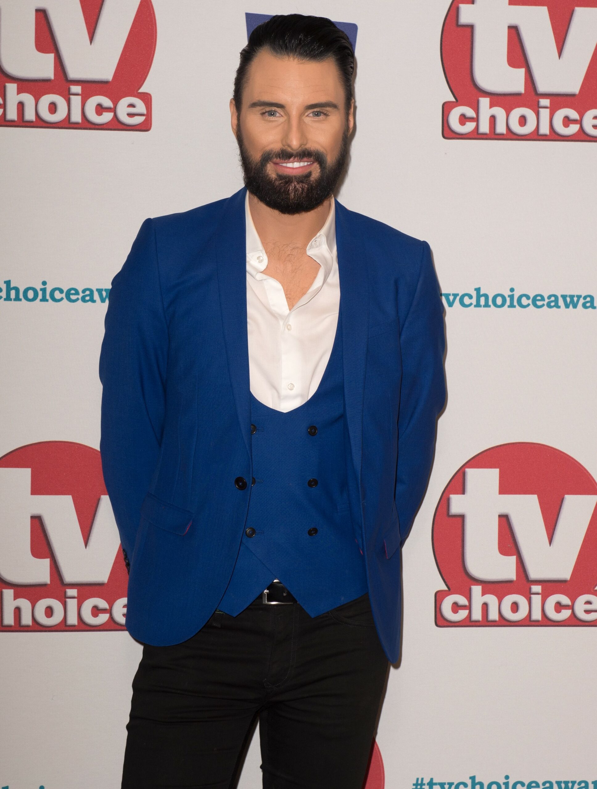 Rylan Clark smiling in blue suit jacket
