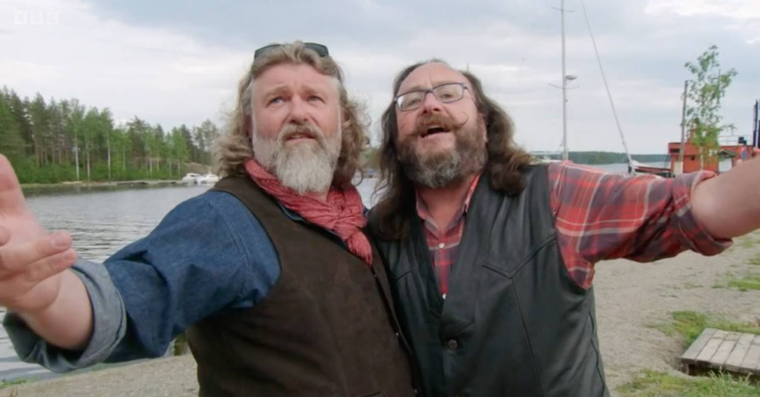 Si and Dave from The Hairy Bikers sing into the camera, their arms flung open