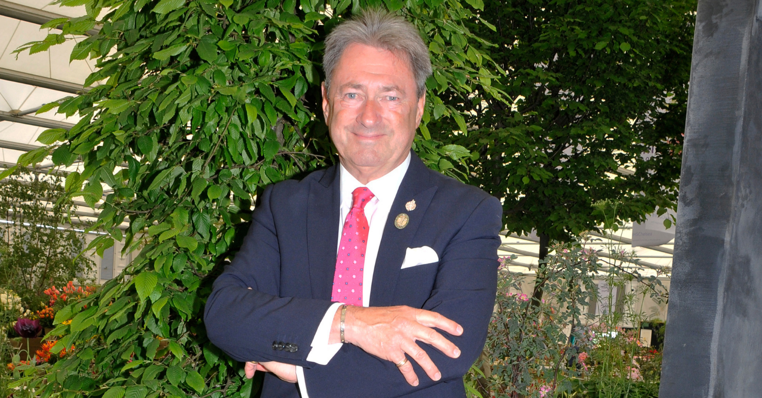 Alan Titchmash smiles for the camera with arms folded across his body