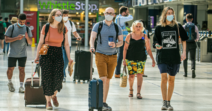 Travellers in Waterloo train station wearing facemasks