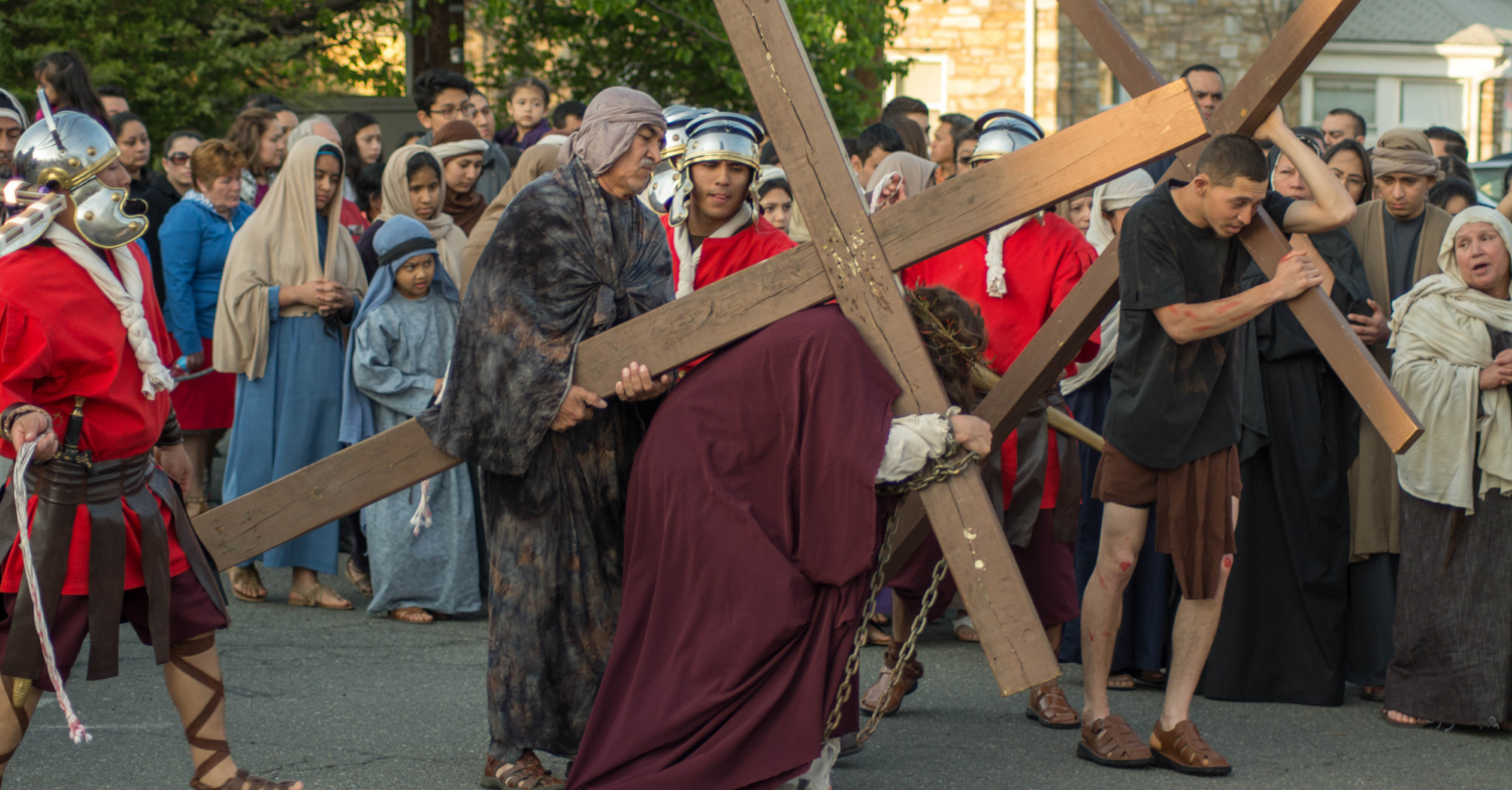 A re-enactment of Jesus walking through a crowd with a cross