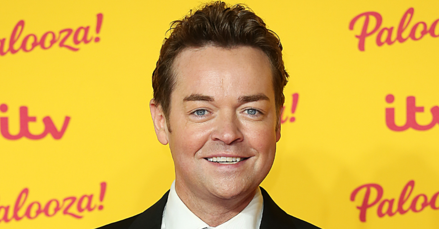 Stephen Mulhern smiling on the red carpet in a suit