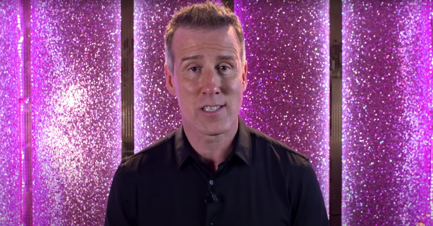 Strictly star Anton Du Beke in a black shirt against a pink sparkly wall