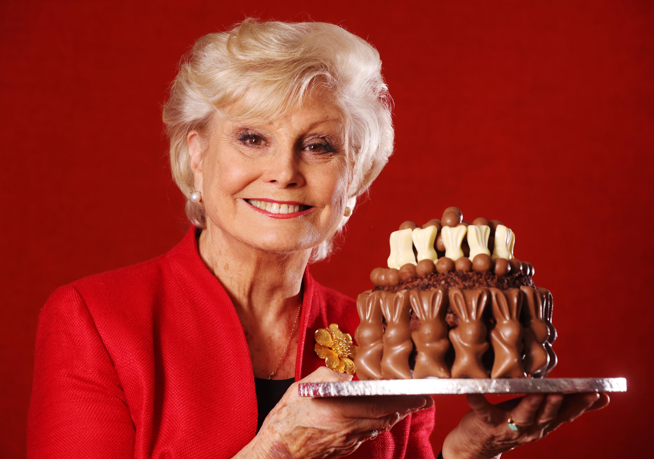 Angela Rippon holding a chocolate cake