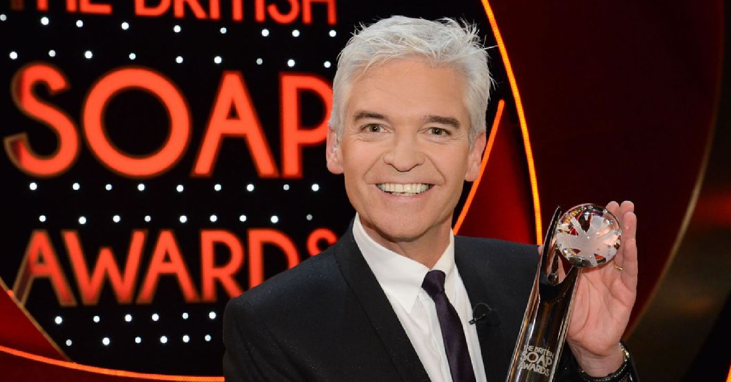 Phillip Schofield grinning as he holds a British Soap Award 